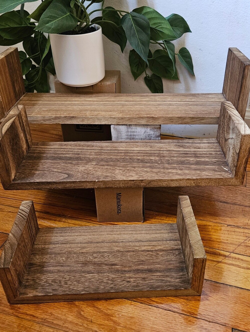 A set of three nested, U-shaped wooden floating shelves They showcase a rustic a